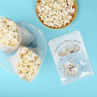 we can bearly wait Popcorn in paper cones with a small card featuring a bear design on a blue background