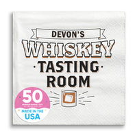 A white paper napkin with 'WHISKEY TASTING ROOM' printed in black text and a graphic of a drink glass.