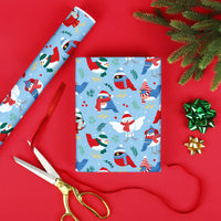 Christmas-themed wrapping paper with cartoon winter birds on a red background with scissors and bows.