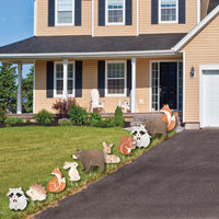 Decorative baby shower animal figures on a lawn in front of a house