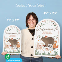 Woman holding two signs with animal illustrations and text, against a blue background.
