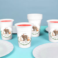 White cups with animal-themed designs forrest animal baby shower party essentials on a blue surface