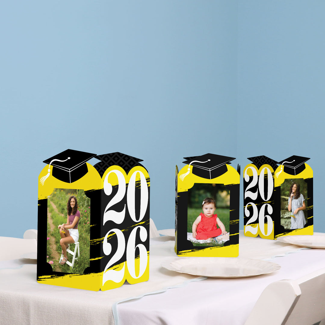 Yellow graduation party table with photo holder decor