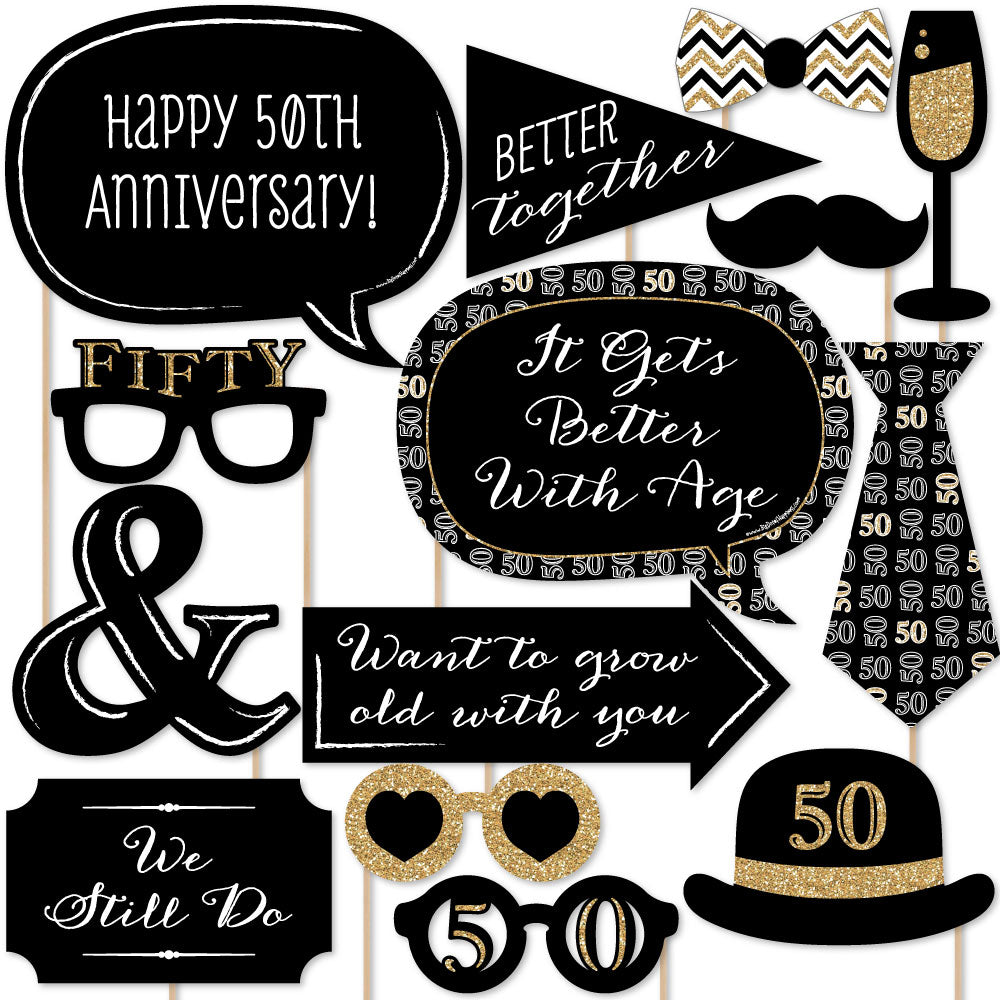 A collection of 50th anniversary themed photo booth props including signs, glasses, mustaches, lips, and other playful accessories.