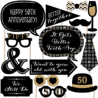 A collection of 50th anniversary themed photo booth props including signs, glasses, mustaches, lips, and other playful accessories.