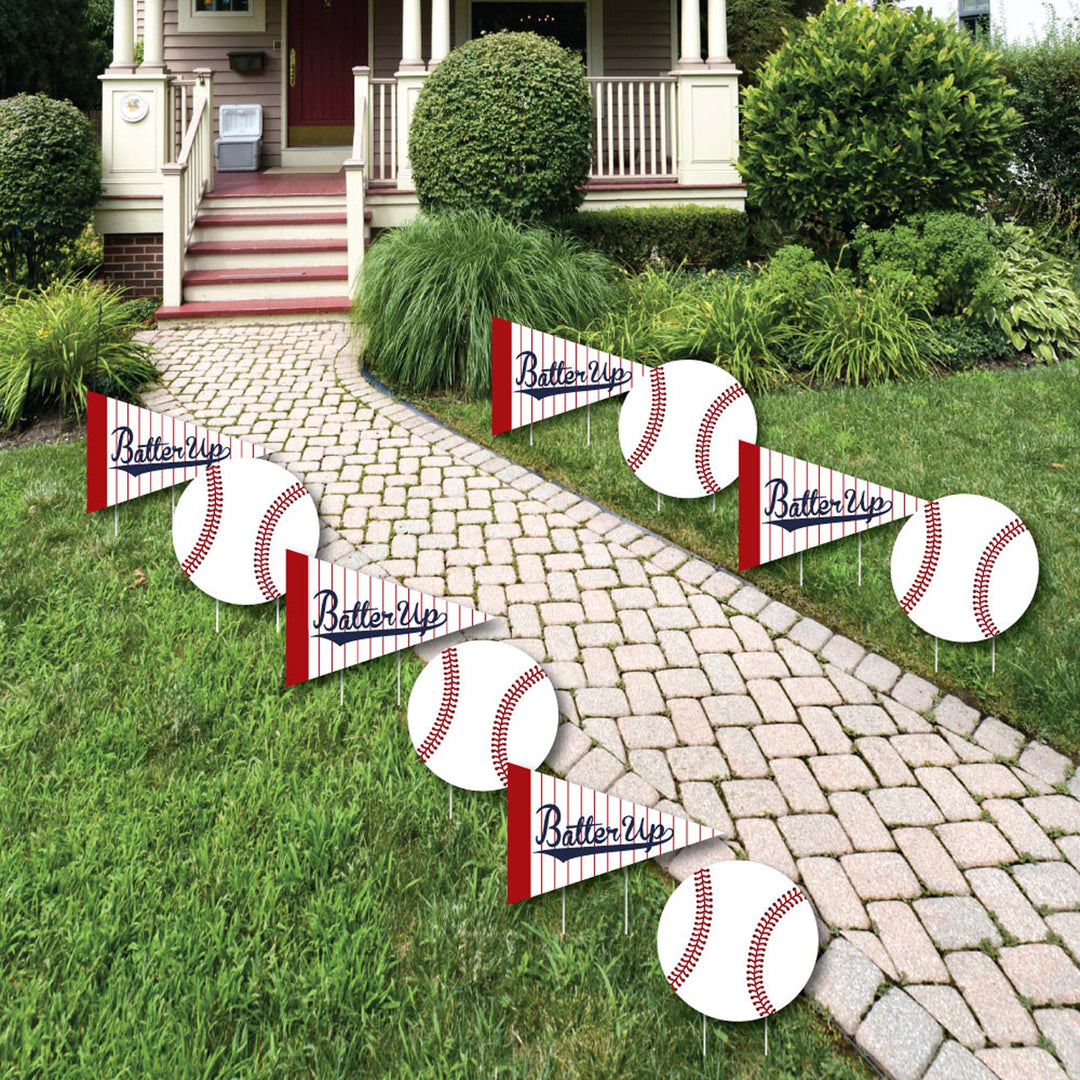 A set of 'Batter Up - Baseball' themed lawn decorations displayed on a garden path, consisting of signs with baseball designs and the phrase 'Batter Up' printed on them.