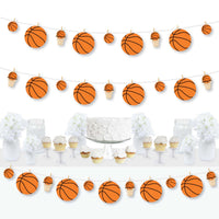 A basketball-themed clothespin garland banner featuring orange and white basketballs, displayed at a party with a cake and cupcakes in the foreground.