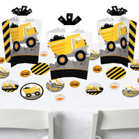 Construction themed party supplies including fold and flare centerpieces with construction trucks and confetti in yellow, black, and gray colors.