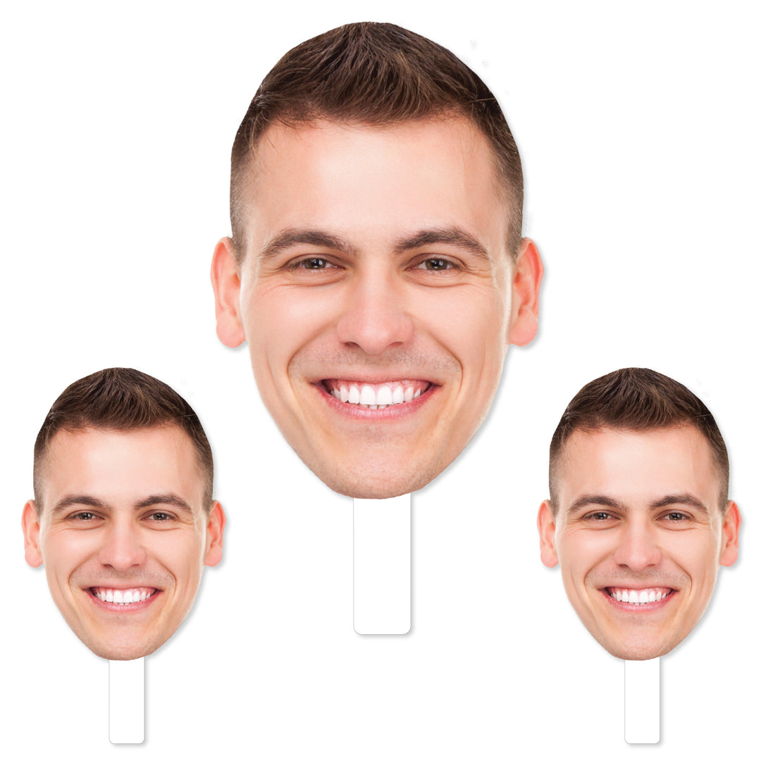 A set of three custom photo props featuring a smiling face, with one large head cutout and two smaller heads, all in white. Head on a stick