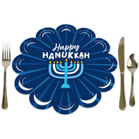 A round, blue paper charger with a scalloped edge and a 'Happy Hanukkah' message, featuring a menorah in the center. The charger is displayed with a fork on the left and a knife on the right, representing a place setting.