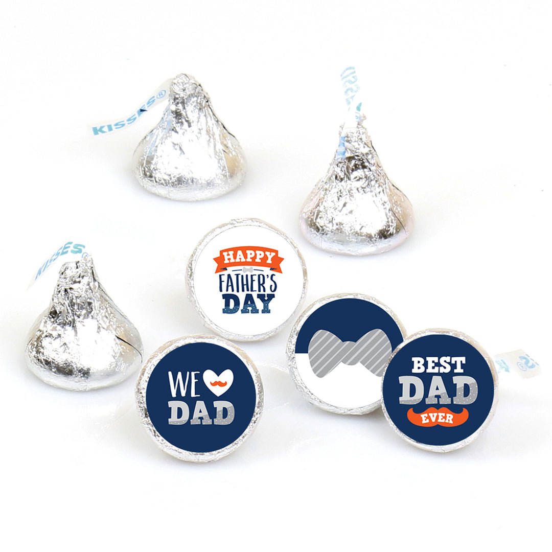 A collection of round candy stickers with various Father's Day-themed designs, including text and graphics such as 'Happy Father's Day', 'We Love Dad', and 'Best Dad Ever'. The candies are silver-colored with blue and orange decorative elements.