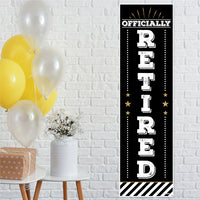 A vertical 'Happy Retirement' banner with a black background, white text, and gold accents, displayed alongside yellow balloons and a gift box.