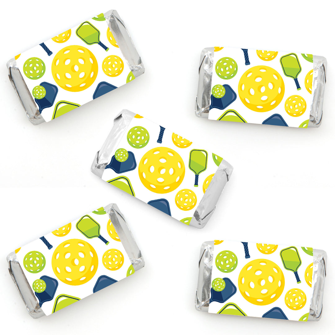 Mini candy bar wrappers with a pickleball pattern, including yellow, blue, and green colors.