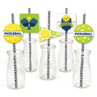 A set of paper straw decorations with striped patterns and pickleball-themed designs, including cut-outs of yellow and green pickleball shapes, pennants, and square shapes. The decorations are displayed in clear bottles and against a white background.