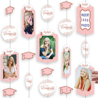 A rose gold graduation party decoration kit with hanging vertical photo garland, including cut-out shapes of frames, circles, and graduation caps with clear cording.