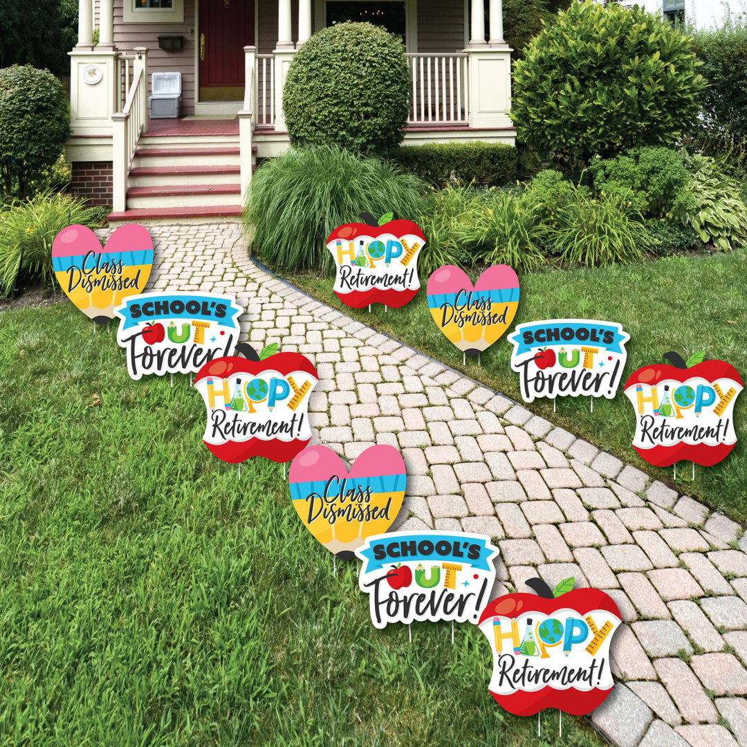 A set of colorful Teacher Retirement lawn decorations displayed on a garden path, featuring shapes like pencils, apples, and hearts, with text such as 'School's Out Forever', 'ClassDismissed', and 'Happy Retirement'.