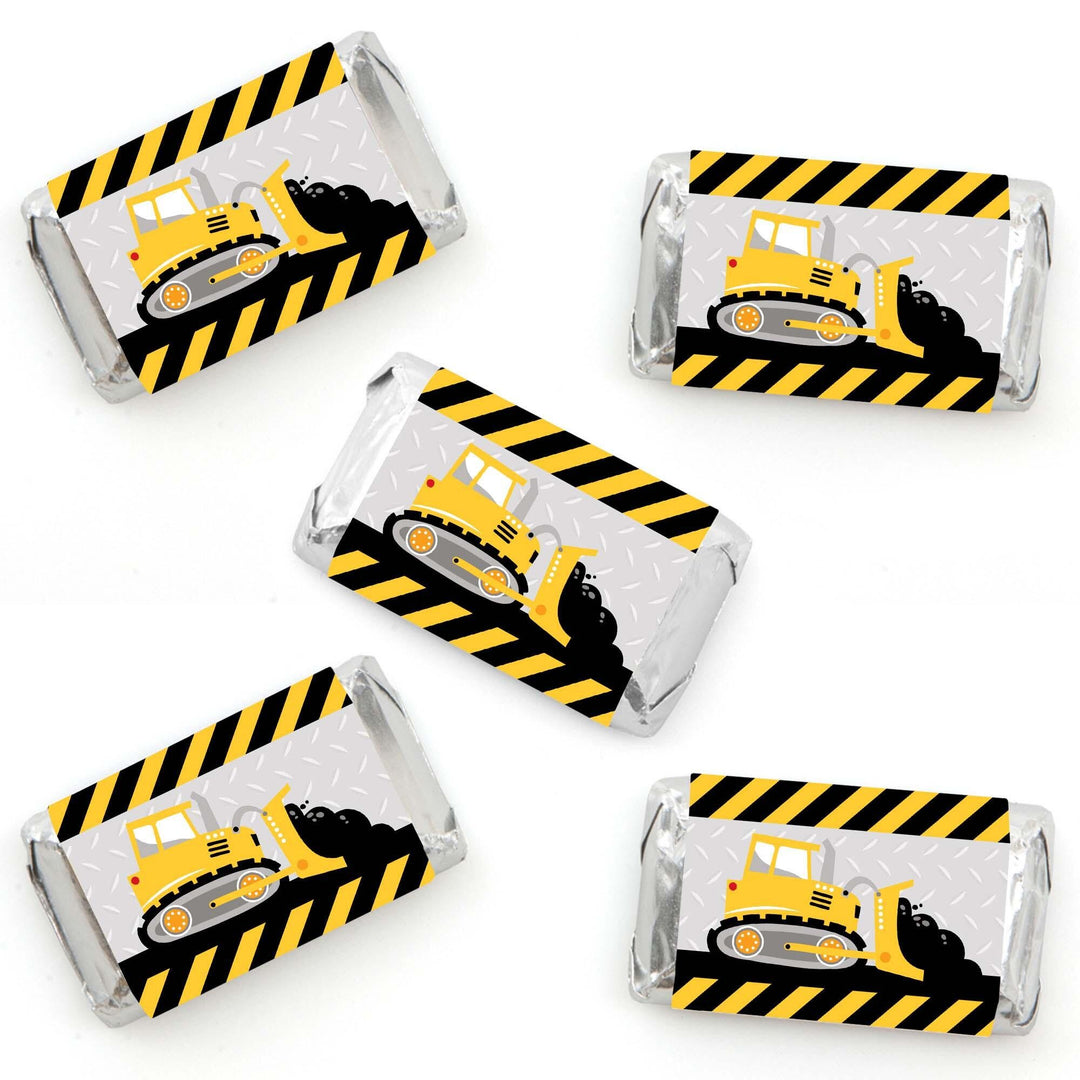 Mini candy bar wrappers with construction truck design, yellow and black striped pattern.