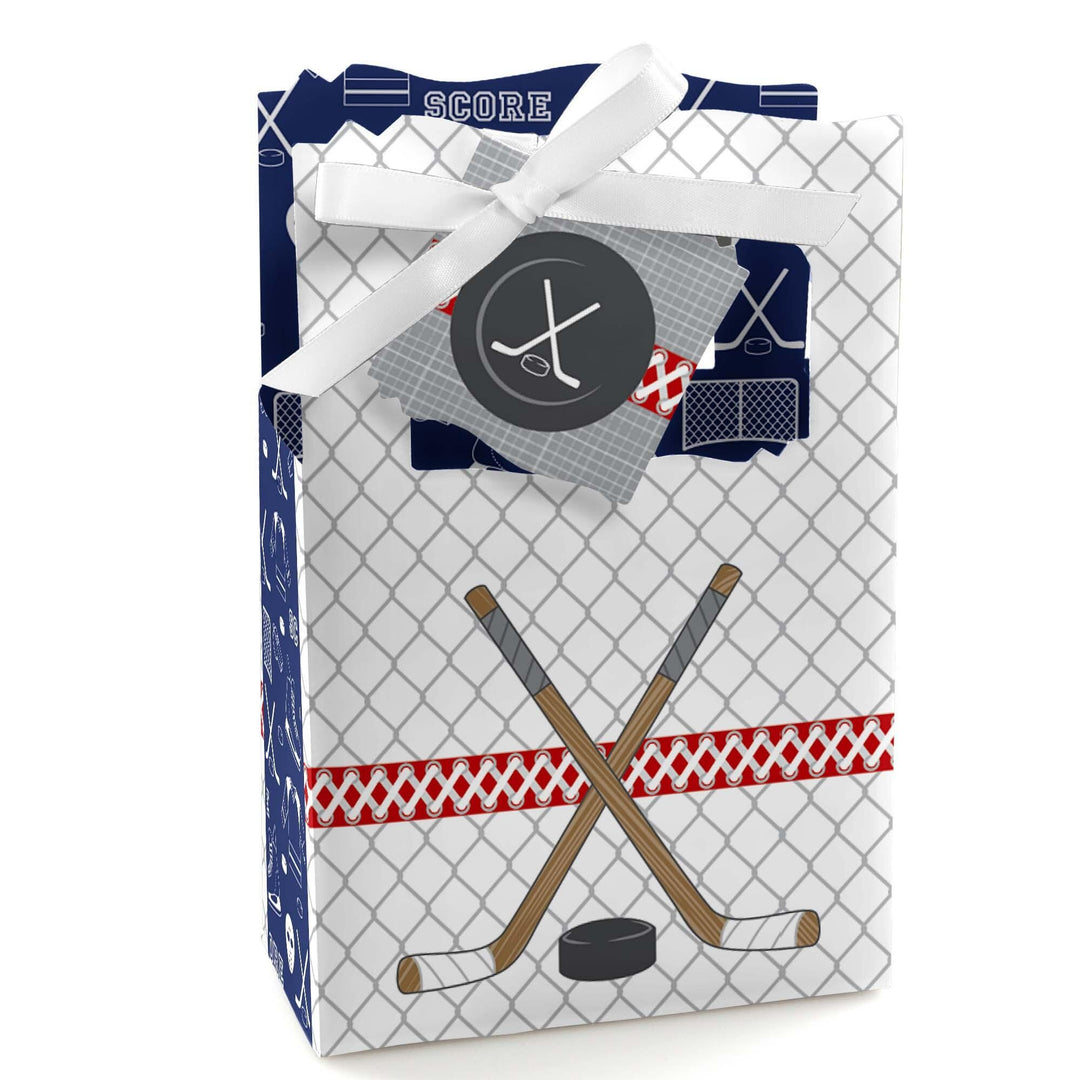 A favor box with a hockey theme, featuring a white ribbon, blue and red accents, and an emblem with a hockey stick and puck.