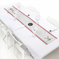 A paper table runner with a hockey theme, featuring red and white colors and decorative elements, laid out on a white tablecloth.