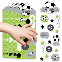 A collection of soccer-themed stickers including balls, stars, and text that reads 'GOAAAL!' displayed on a child's hand.