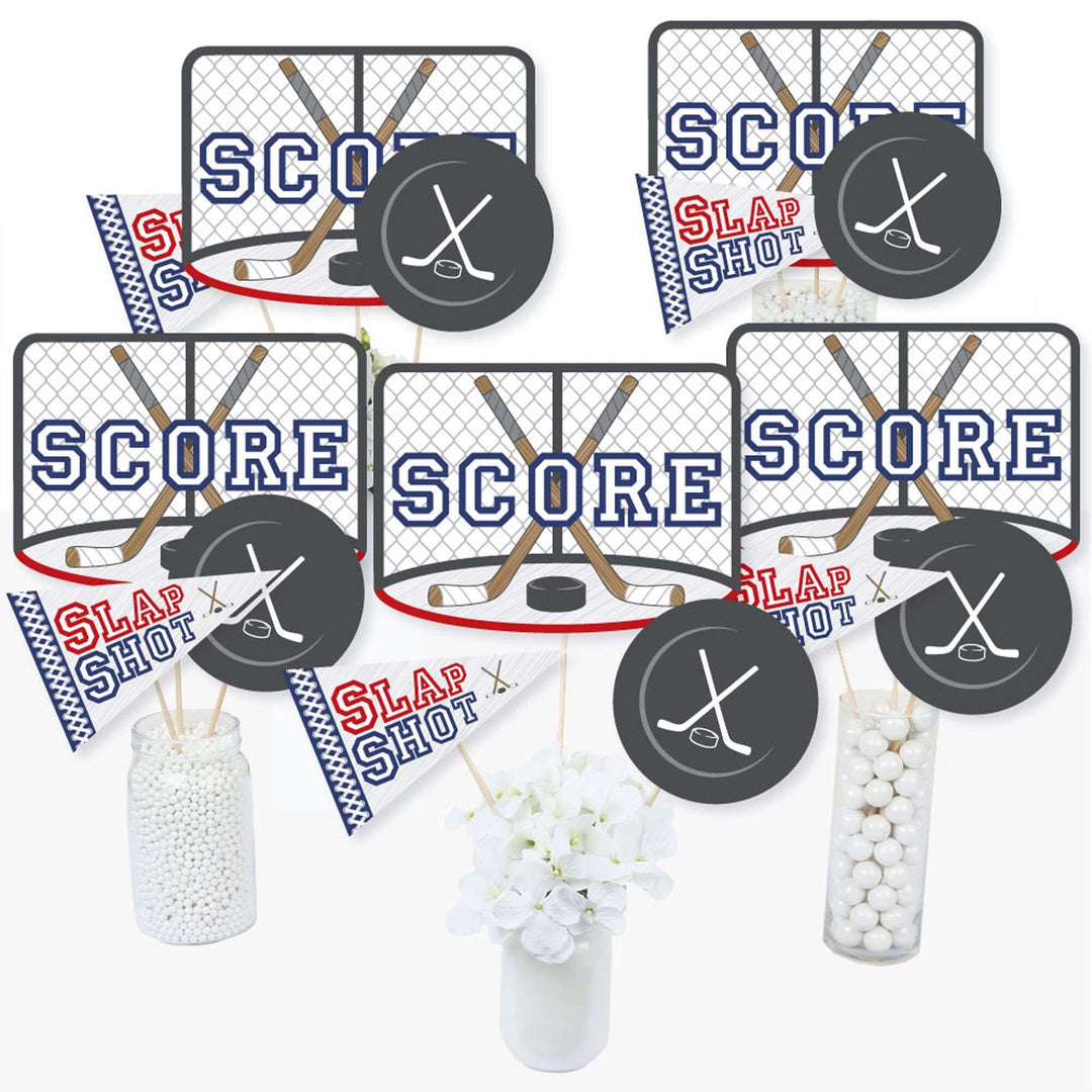 A set of hockey-themed centerpiece sticks with 'SCORE' and 'SLAP SHOT' text and hockey puck designs, intended for use at baby shower or birthday parties.