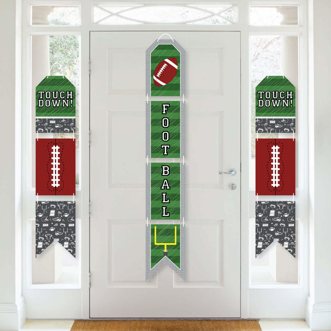 A set of vertical hanging paper door banners for a football-themed party, featuring numbers and football graphics in green, white, and red colors displayed on a white door.