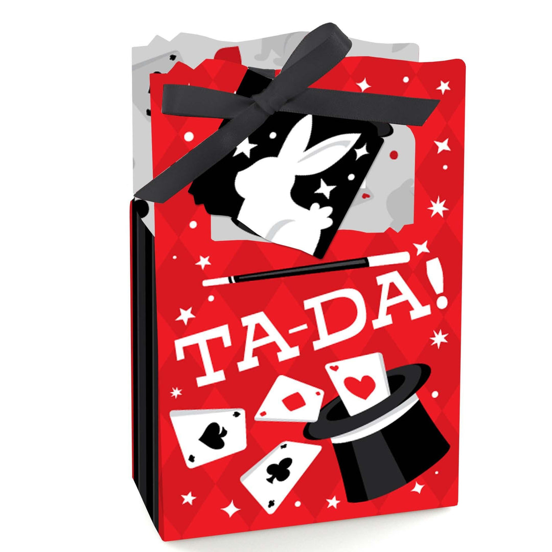 A red favor box with a 'Ta-Da'  magic party text and illustrations of a rabbit, hat, and cards, tied with a black ribbon.