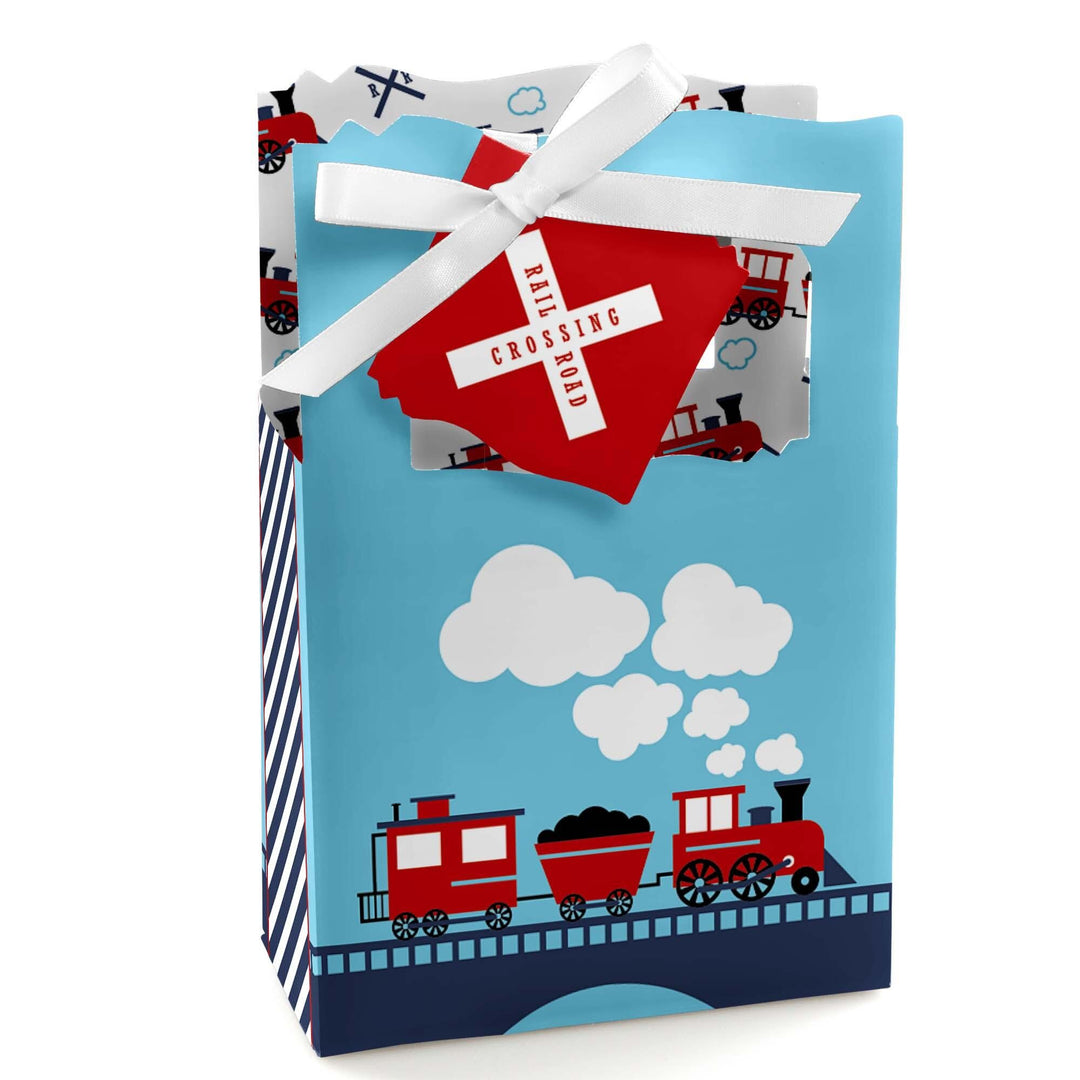 A favor box with a blue background featuring red steam trains and white clouds, tied with a red ribbon.