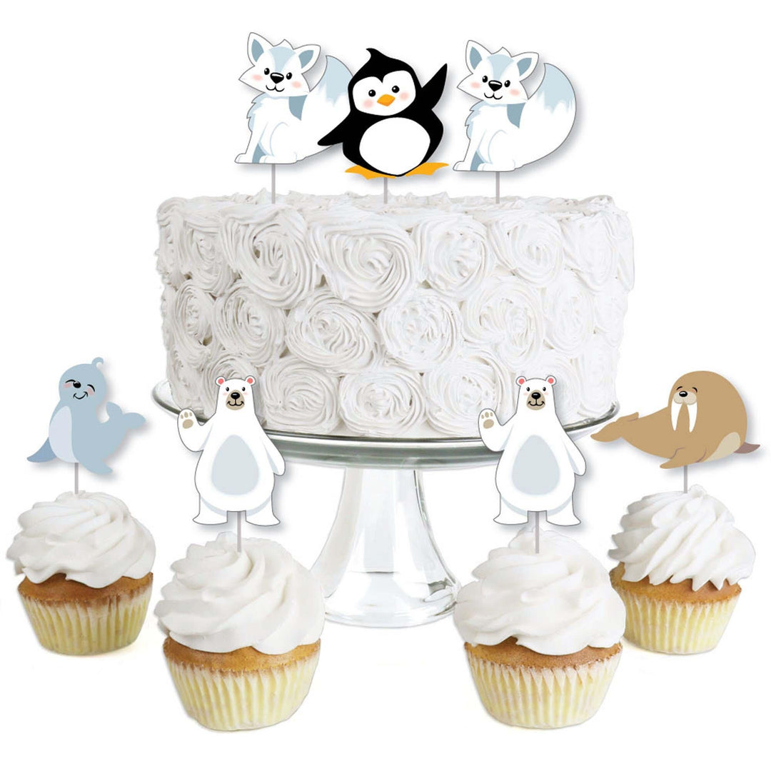 A set of dessert cupcake toppers featuring Arctic polar animals, including cutouts shaped like penguins and seals, attached to clear treat picks, displayed on a white cake and cupcakes.