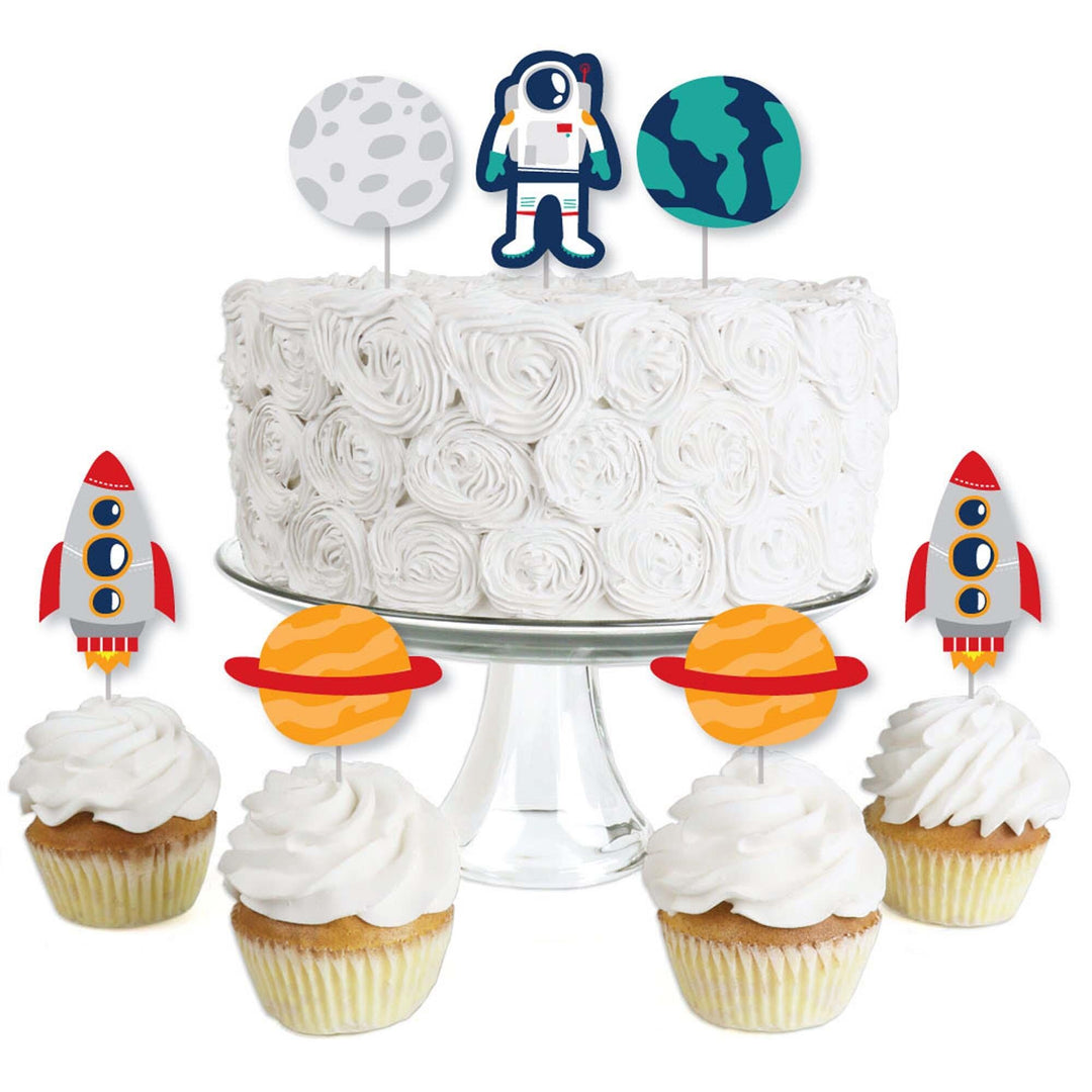 A set of dessert cupcake toppers with rocket ship and outer space themed designs, including clear treat picks and printed cut-outs displayed alongside a cupcake.