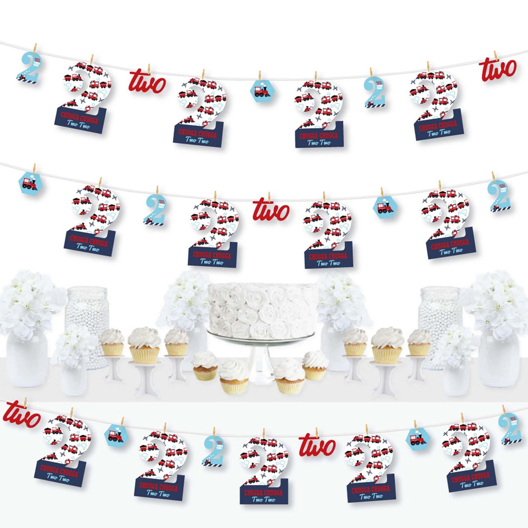 A set of 2nd Birthday Railroad Party Crossing decorations featuring paper cut-outs, mini clothespins, and a clothespin garland banner arranged to form the numbers '2' and '0' along with train tracks and steam trains.
