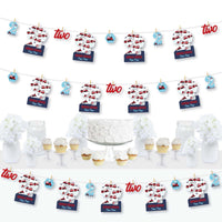A set of 2nd Birthday Railroad Party Crossing decorations featuring paper cut-outs, mini clothespins, and a clothespin garland banner arranged to form the numbers '2' and '0' along with train tracks and steam trains.