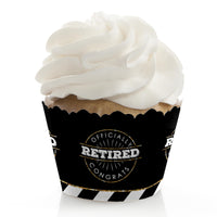 A cupcake with a Happy Retirement party decoration wrapped around its liner.