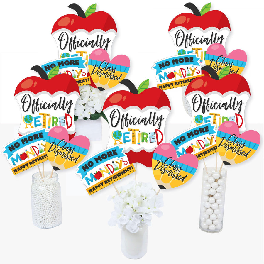 A collection of colorful teacher retirement party centerpiece sticks with various退休-related phrases and apple designs, displayed in vases and on tables.