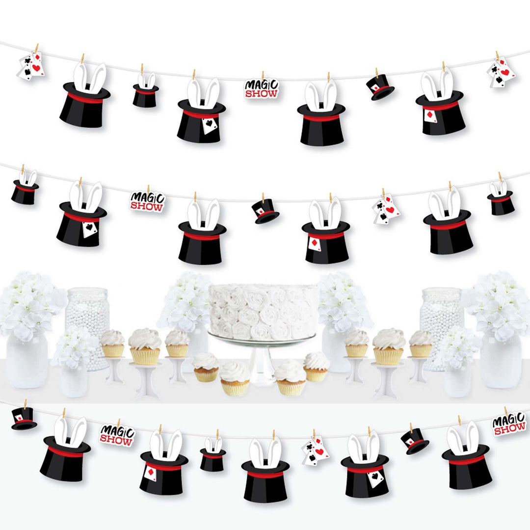 A set of decorative garland banners featuring paper cut-outs of magic hats and magic wands, with a white cord and mini clothespins, arranged for a party decoration setup.